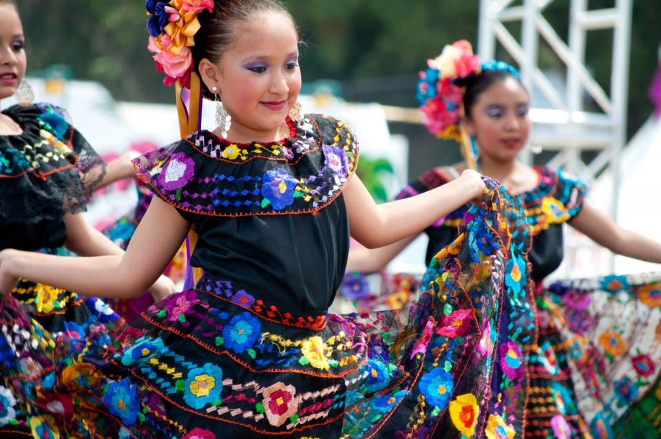 Child dancing folklorico in colorful outfit