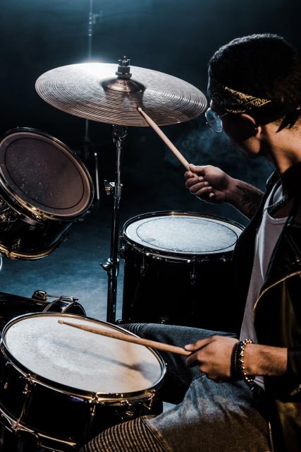 Side view of person playing drums