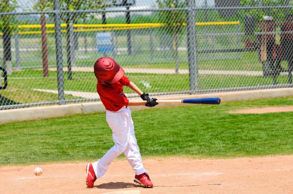 Youth swinging a baseball bat