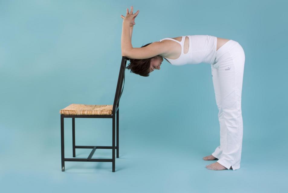 Person using a chair for assistance in yoga