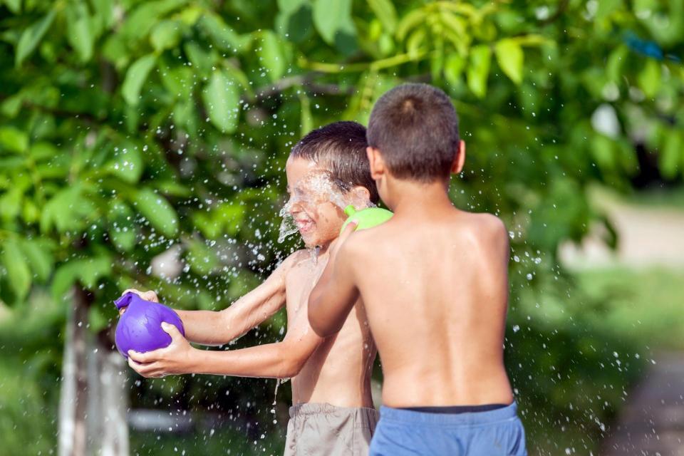 Two boys playing with water balloons