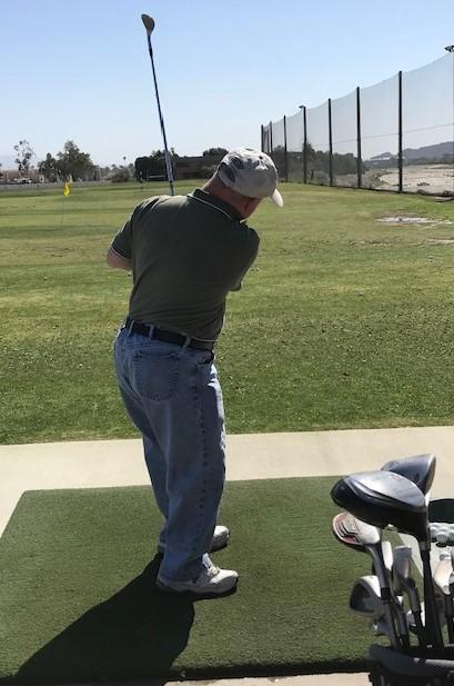 Adult playing golf on driving range